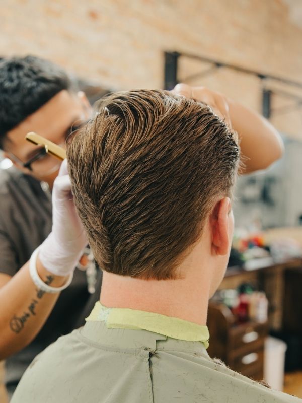 Barber performing a precision fade at Traditions